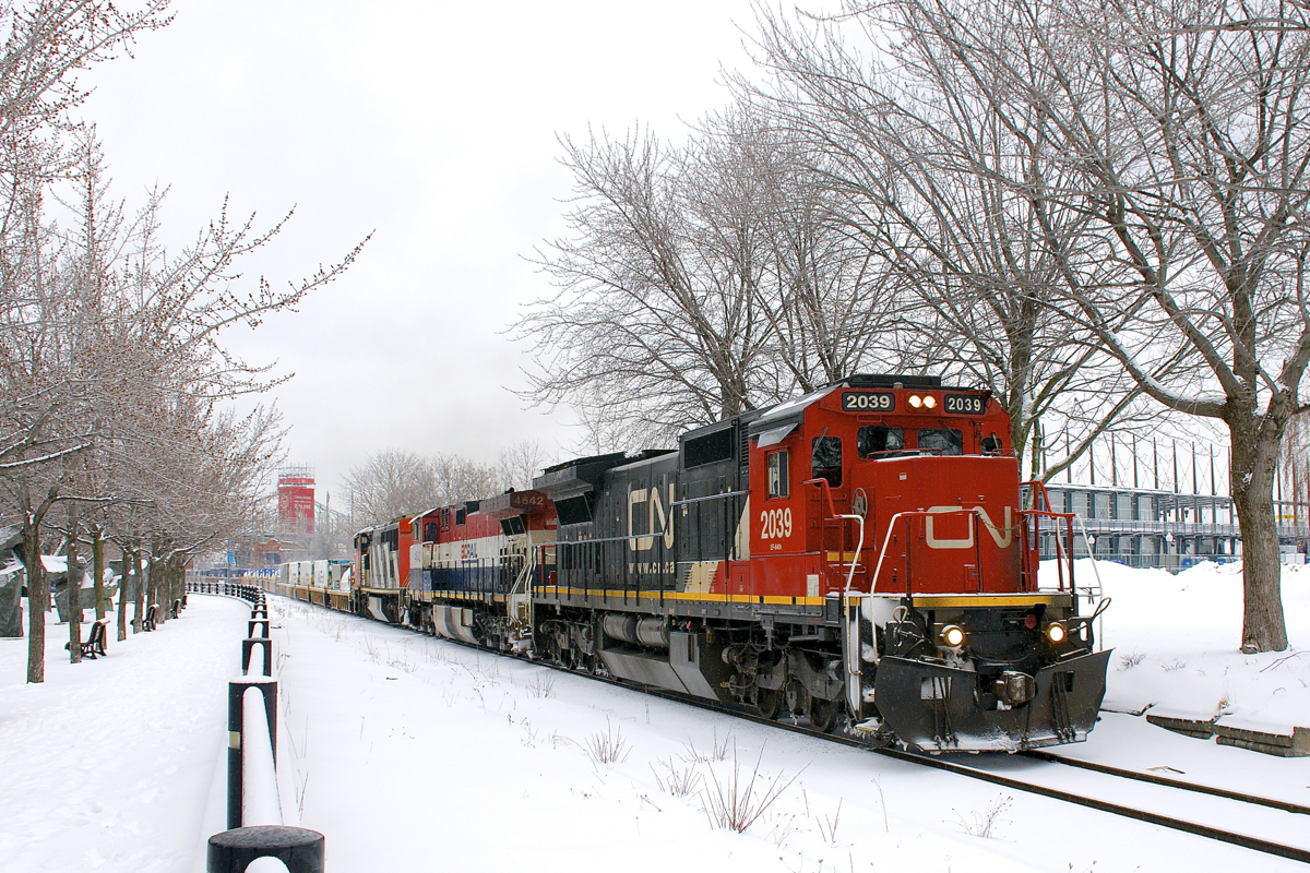 CN 149 is leaving the Port of Montreal with a variety of GE units: C40-8 CN 2039, Dash9-44CWL BCOL 4642 & Dash8-40CM CN 2420. Behind the power is 12,200 feet of platforms.