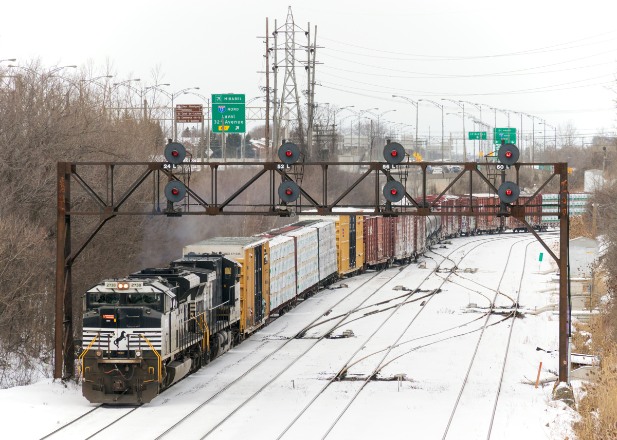 A later than usual CN 528 snakes out of Taschereau Yard as it crosses over from the north track of CN's Montreal Sub to the south track. Power is NS 2738 & NS 8947.