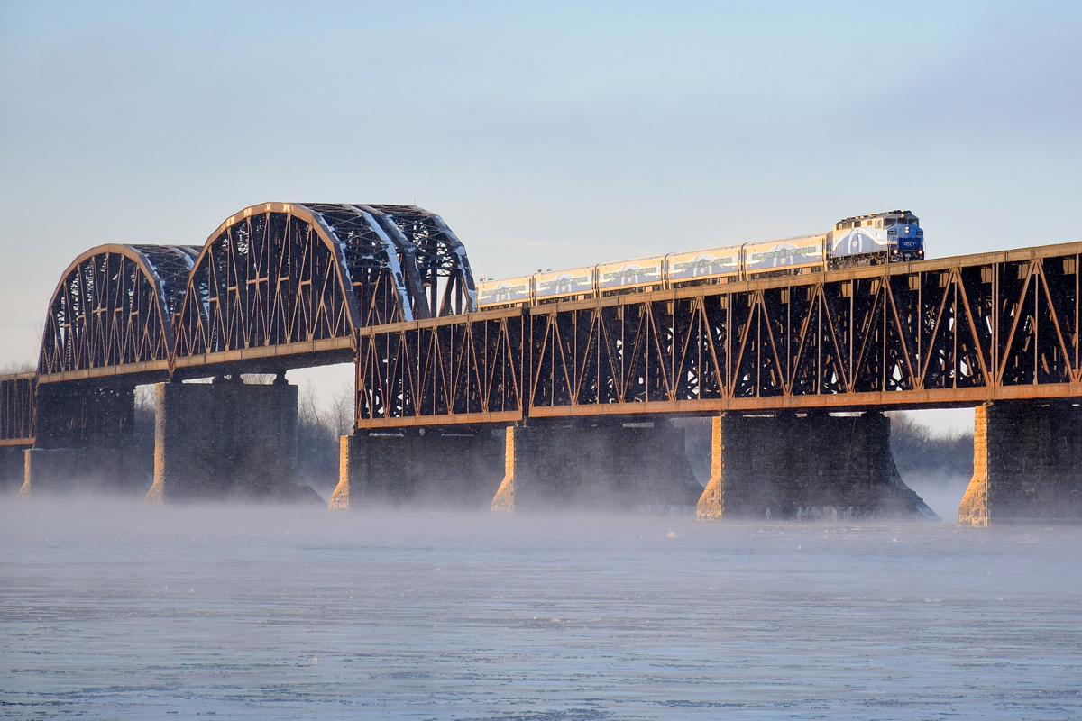 As cold as it looks. It's about half an hour after sunset and a frigid -15 celsius (5 fahrenheit) as AMT 76 makes its way across the St. Lawrence River towards Montreal with ex-GO Transit F59PH AMT 1343 for power.