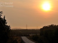 <b><I>Sunrise on the Kashabowie.</I><b/>
Regional forest fires cover the north in a smoky haze as Thunder Bay bound grain train blasts its 14L for the Highway 11 crossing just west of the small hamlet of Shebandowan.<br>
<I>Of note: This was the first DPU'd train CN ran on the Kashabowie. I can't recall the number of cars but I believe it was in the neighbourhood of 150-160 cars. An absolute monster! And this practice today has become common on bulk trains into the Lakehead, some pushing this threshold in the 200+ car total. Power CN ES44DC 2236- CN SD50F 5459 with CN ES44DC 2267 pushing on the rear</I> 