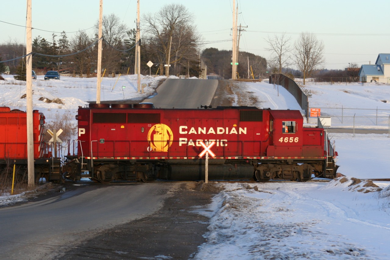 During a late February afternoon, the Hamilton Turn is seen switching over Greenfield Road in Ayr, Ontario with GP40-2 4656 and GP9u 8234.