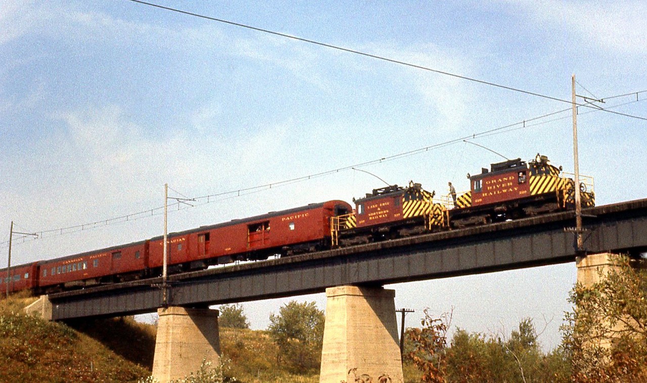 Operating on an Upper Canada Railway Society Fan trip, Grand River Railway electric freight motor 228 and Lake Erie & Northern Railway 337, the last electrics, cross the LE&N bridge over the CASO (NYC) at Waterford on September 30th, 1961. Passenger operations had already ended a few years prior in 1955, and this would be the last day of electric operations on GRR-LE&N, as parent Canadian Pacific's diesel locomotives would take over operations on the "CP Electric Lines" the next day (October 1st, 1961).