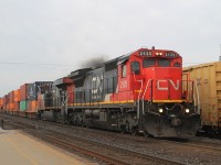 This morning's all-intermodal passes through Brantford and the lead loco emits black smoke as it applies the power. CN2229 is the second loco.