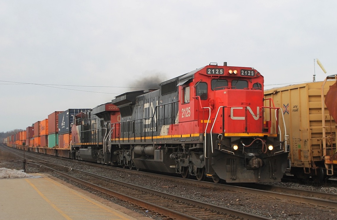 This morning's all-intermodal passes through Brantford and the lead loco emits black smoke as it applies the power. CN2229 is the second loco.