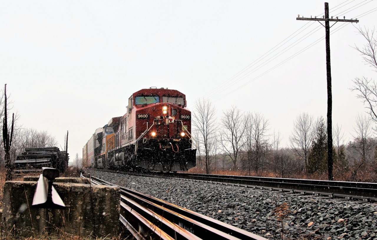 Through a light snow and drizzle, CP 9600 with CSX 3418 accelerate past MM 52 and Side road 10 on their way to Guelph Junction.