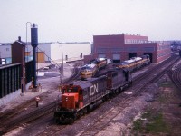 I still remember this day vividly. For a Victoria Day weekend, it was stifling hot around North Bay. In the high 80s (F), and with all the rock and pavement near the Shop, it felt like 100. Still, I am so glad I at least made a quick trek up onto the Main St overpass and captured this image at the ONR diesel facility. CN 5019 and 5054 moving around, I am guessing to get into position to take a train south to Toronto; but the fact there are four F units out front of the shop certainly indicates the age of this image. I wish I had recorded the unit numbers......oh well..........
It is worth mentioning that this sub-standard photo is the results of the cropping of an old Instamatic square slide, besides being tired by time this camera certainly wasn't the best equipment to make a trip to North Bay with, but it was better than nothing.