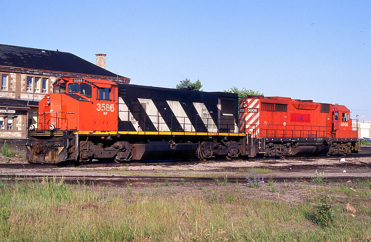 It used to be CN and CP power. But by 1999, the x-CN 3586 and x-CP 5006 became part of the Railink fleet, seen here in front of the old North Bay CP station. At the time of this photo this yard area was the hub of the RLK-Ottawa Valley.  Since this photo was taken, the city went under an ambitious renewal project in which the yard was relocated south and the mainline shifted toward the waterfront as a thin corridor to enable the city to develop prime downtown area for parks and recreation. The station is preserved and serves as a museum among other things.