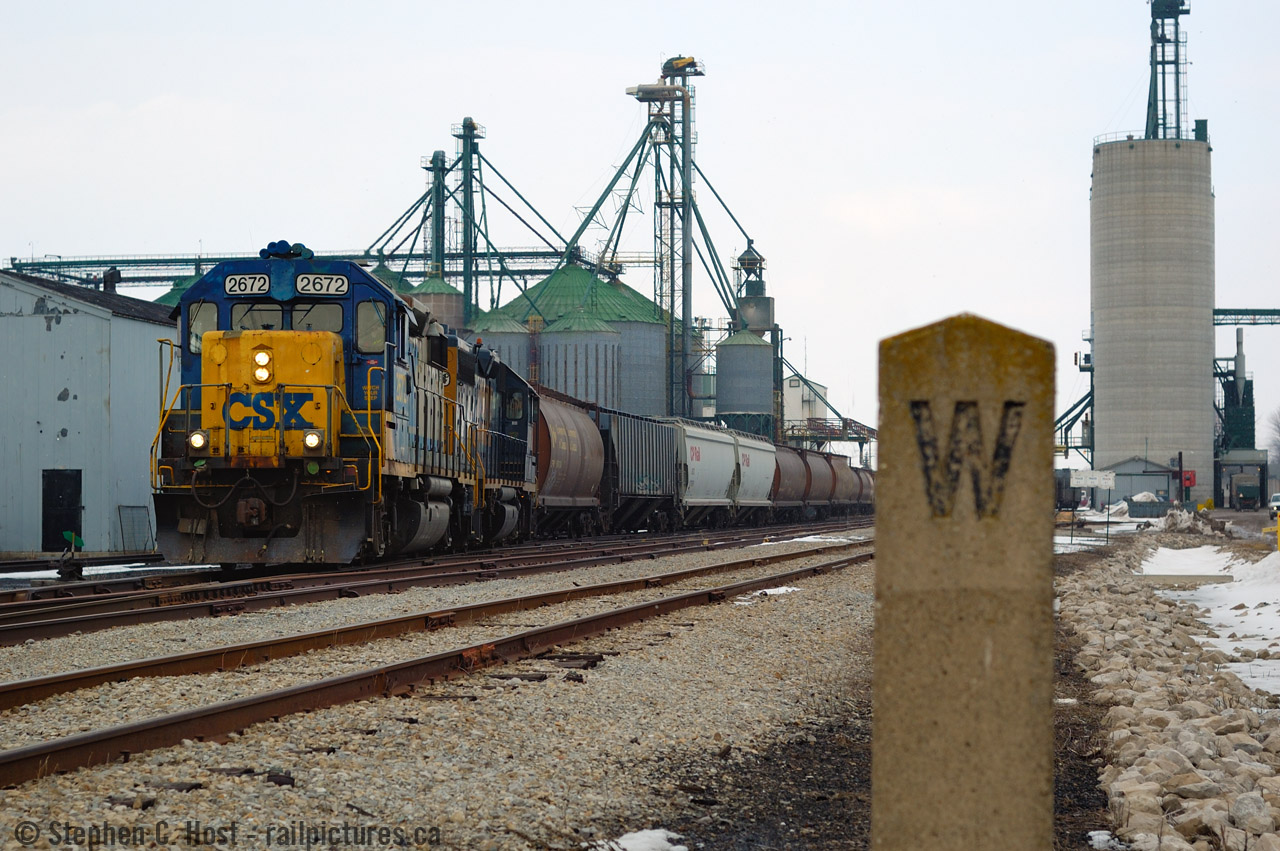 CSX Train D724 is seen working the huge (Words do not describe the size of this complex) W.G. Thompson and Sons elevator at Blenheim, Ontario on the former St. Thomas to Walkerville east/west mainline of the C&O. A nice feature of the Sarnia and Blenheim subs are concrete whistle posts and mile markers - they date to the Lake Erie and Detroit River Railway, possibly even earlier. (And of interest, the LE&DRR Still owns the land and leases the rest of the line to CSX to this day). D724 was a Chatham -> Blenheim -> Sarnia turn two days a week (Tues/Thurs) and a Sarnia -> Sombra turn Mon/Wed/Fri.  D724 still runs occasionally to Sombra, but Blenheim track is now under CN ownership with sporadic service at best from CN 511 based in Chatham. 
And in the usual custom, I'd like to take you into the Wallaceburg RTC office with a track release as D724, Southbound for Blenheim, releases Chatham yard limits to the RTC and is given the OK to enter rule 105 at Blenheim 8 miles south.Click here - 750kb mp3