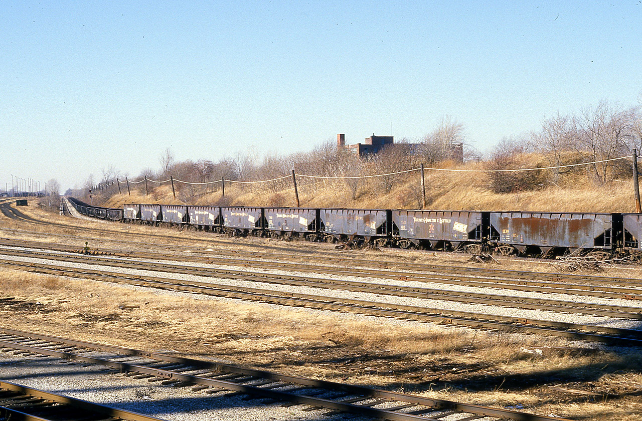 The main reason I am posting this shot is for Historical Purposes, as there are a number of TH&B devotees on this site. So where did all that old TH&B rolling stock go? Here is a long string of cars no doubt heading for the scrapper. Perhaps to the United States. I never did find out. RIP.