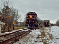 Trillium Ry. 1859 stops and waits for the conductor to throw the switch.  1859 just dropped the car in the siding, has run around it, and is lifting it for the trip to the Port Colborne Grain Terminal.<br><br>Originally laid through Port Colborne in 1853 by the Buffalo, Brantford & Goderich Railway, the Dunville Sub came under control of the GTR, in turn becoming the CNR in 1923.<br><br>TH&B built their own Dunnville Sub from Smithville, ON through Dunnville to Port Maitland on the shores of Lake Erie.  The TH&B wished to access the industries of Port Colborne and gained running rights in 1927 over the CN Dunnville Sub from approximately mile 37.42 to about mile 19.65, where TH&B trains would turn south on what is now the Trillium Railway Government spur and head to the Port Colborne Grain Terminal and ADM Milling.<br><br>TH&B running a rights were still used in 1987 (60 years since first obtained) when TH&B was amalgamated into CP Rail.  In 1988 the running rights were not renewed, and TH&B in Port Colborne was finished.<br><br>Today, there is a laneway running parallel to Clarence Street and Charlotte Street, it sits between the two streets.  It is to access the rear parking lot of the TD Canada Trust bank.  Immediately behind the bank the TRRY Government spur crosses this lane.  One of the cross bucks is mounted on a wooden post.  On the rear of the post, under reflective striping, sits the lettering; <b><i>TH&B Ry.</i></b><br><br>I wish I could have found more history of the operations of Port Colborne and Macey Yard, but this is all.  If anyone knows anything of these lines, please leave in the comments.