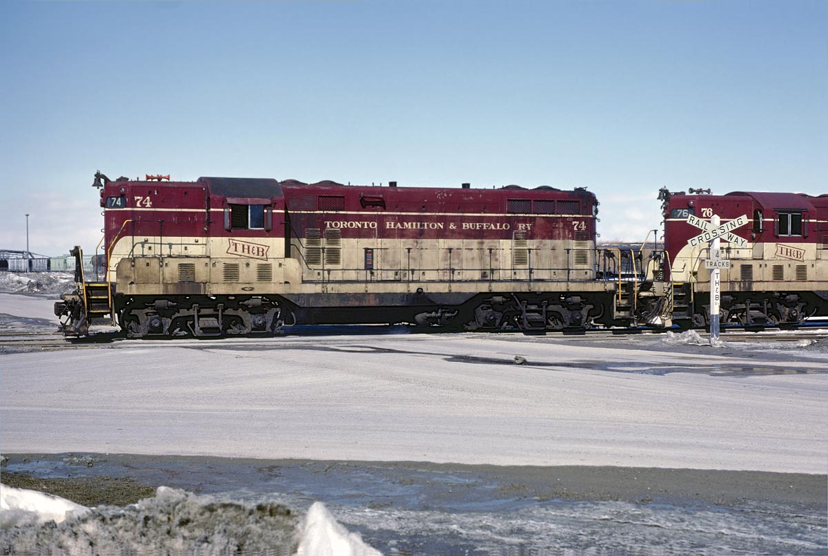 GP-7 #74 leads a phosphate train through the yard at Port Maitland on February 28, 1982.  This would be a pretty routine broadside of a GP-7 without the TH&B lettered crossing sign.