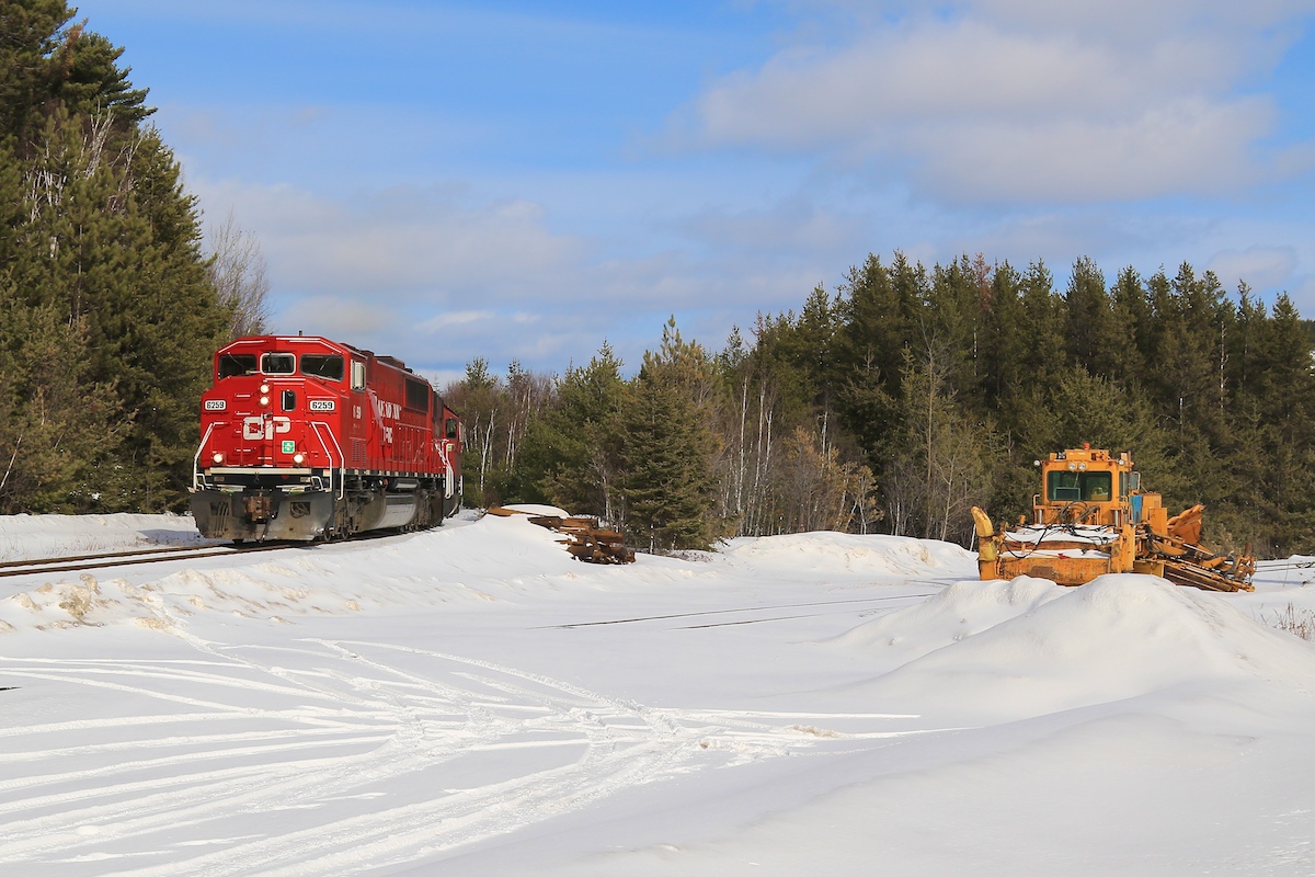 With 38 loaded cars of nickel ore, ex-Soo locomotives 6259 and 6230 slowly crawl up the hill from Levack and back to the rails of the Cartier Sub.  The MOW equipment on the right always comes in handy with this section of track in the winter months.