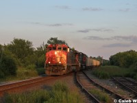 CN 2512 leads a train of empty gypsum cars from Wrights Cove en route to Milford, NS.  The train is catching some golden rays of run with a beat up locomotive on the point.