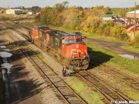 CN 2585 and 2558, (both C44-9W's) idle ahead of the switch, while the conductor is currently changing the points so the power can reverse onto the GP40-2W awaiting pickup to assist with the train's tonnage for the remainder of the trip to Moncton, NB.