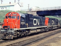 MLW C-630M 2003 with 2018 pass under the Bay St. bridge into Hamilton Stuart St. yard.  This is train 466, one of many trains each on the Grimsby Sub.  
Acorn lumber can be seen at the top left of the picture.  This is now Hutch's Restaurant.  The Bay St. bridge has been replaced with a new span. Where I am standing to take the picture would be about where the north track is for the new West Harbour GO station.  This is now in the area of the STUART interlocking.   