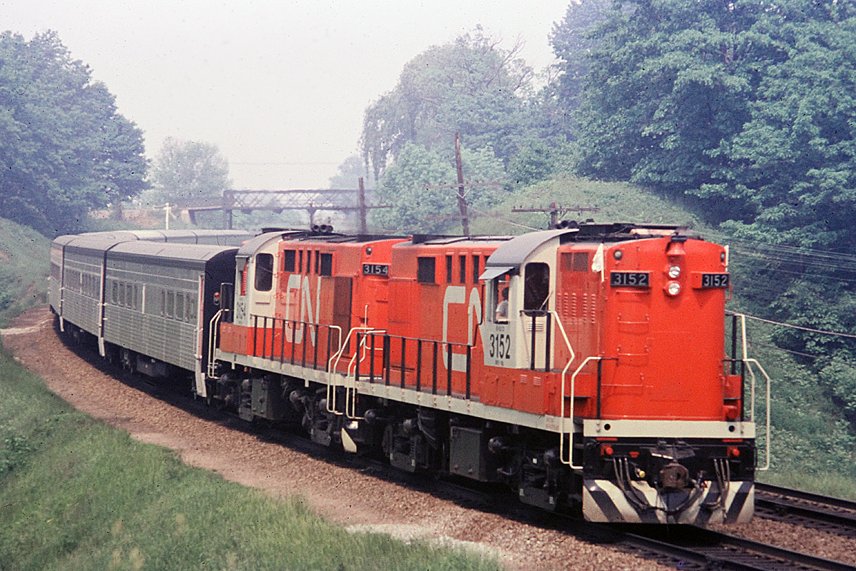 A pair of freshly painted RS-18m Tempo units with Tempo coaches approach Bayview Jct.  The short hoods of these units were extended to house the Head End Power equipment. Interestingly, when these units were converted, they were initially painted in the CN green and gold paint scheme.  They sure looked nice and shiny.