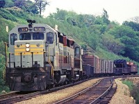 Flying "Extra Flags" CPR 5008 and another GP35 haul a short train near the cemetery on York Blvd in Hamilton, ON.  The date is June 1968.  Note the unusual centre cupola caboose bringing up the tail end of this train.  