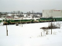 I was very fortunate this eastbound was held at the signal just below the Waterdown Rd bridge in Aldershot. It gave me a chance to grab several shots of it before the light faded. A difference of ten minutes late day makes all the difference in the world. A four unit freight of all GO power was a rarity indeed; this was my only sighting. The power short CN was leasing whenever they could. GO 9801, 9804, 710 and 709 power this train. GO was renumbering all of their 9800s to 700 series at the time. The Kirkelder Spray Mister building is much better known as Aldershot Cold Storage by us photographers of the day. It has been now been leveled. And the main is now three tracks plus two Aldershot yard leads are in the foreground. In the far background is a structure of Cooke Concrete, another defunct business of the area. Only that low building by the lead engine, known to me as "FX" which was a theatre outfit of some sort, is still there to mark the territory.