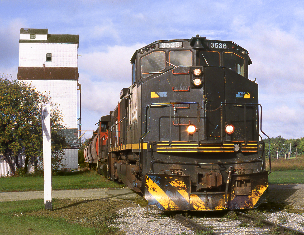 Eastbound Southern Manitoba Railway, who operated CN's former Morris to Elgin branch, picks up grain from the Baldur elevator. The line was originally built by the Northern Pacific to Brandon in 1889 and was a founding component of Canadian Northern.