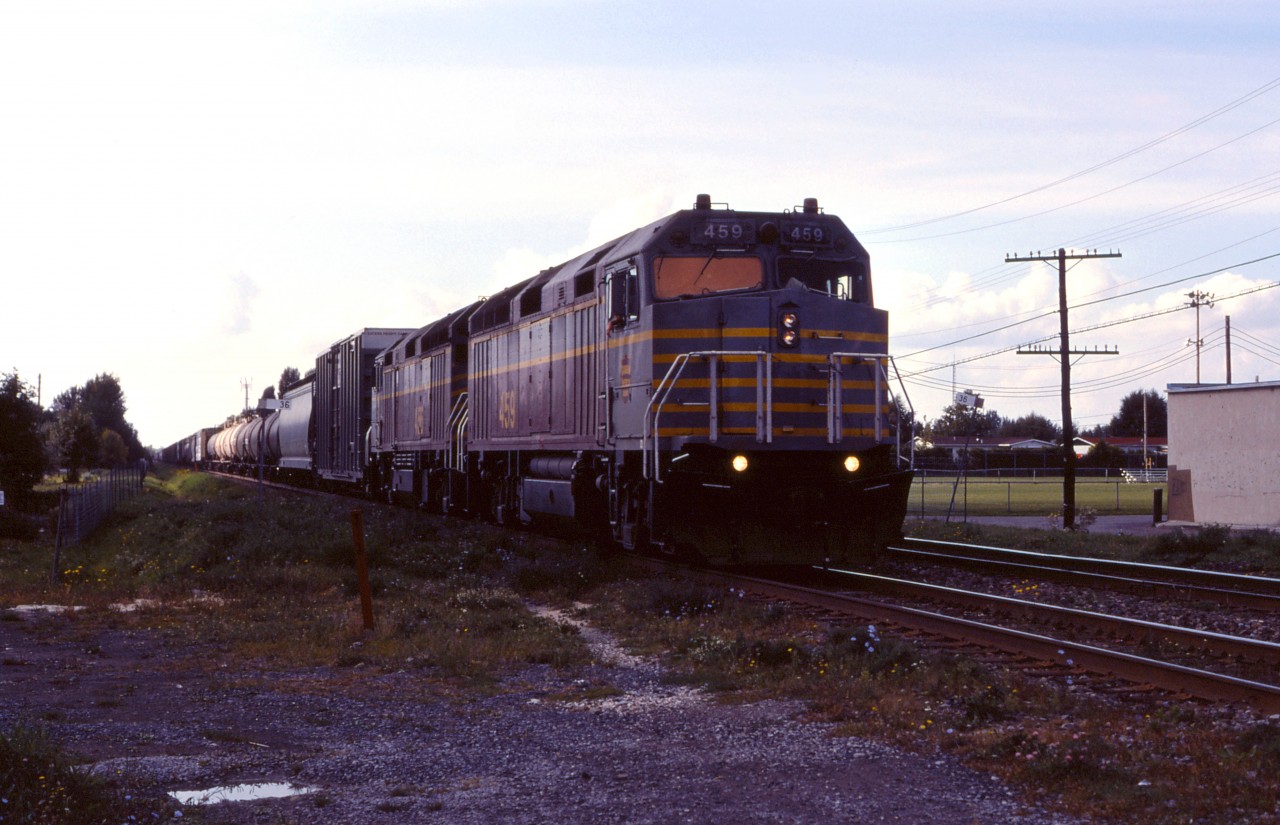 The Canadian American Railroad (CDAC) operated between Brownville Jct, Maine and St-Jean-sur-Richelieu, Quebec between 1995 and 2002. Exercising trackage rights on CP between St-Luc Yard in Cote St-Luc (Montreal)and St-Jean, we have an eastbound, led by F40M-3F 459 (ex-Amtrak 264) and a similar unit as the light fades at the end of the day. 

CDAC and its parent company Iron Road Railways went bankrupt in 2002 and the line was taken over by the ill-fated Montreal, Maine & Atlantic.
