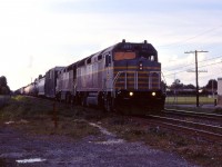 The Canadian American Railroad (CDAC) operated between Brownville Jct, Maine and St-Jean-sur-Richelieu, Quebec between 1995 and 2002. Exercising trackage rights on CP between St-Luc Yard in Cote St-Luc (Montreal)and St-Jean, we have an eastbound, led by F40M-3F 459 (ex-Amtrak 264) and a similar unit as the light fades at the end of the day. 

CDAC and its parent company Iron Road Railways went bankrupt in 2002 and the line was taken over by the ill-fated Montreal, Maine & Atlantic.