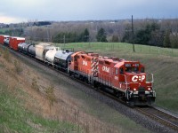CP's Cobourg Turn behind GP9u's 8215 and 8214 heads eastbound on the Belleville Sub at Newtonville, on April 30th 2002. The rebuilt 8200's had their dynamic brakes left intact and transition retained for roadswitcher duties, as opposed to the 15/1600-series Geeps rebuilt without DB or transition (lowering them to maximum 35mph speed) for yard and switching use.