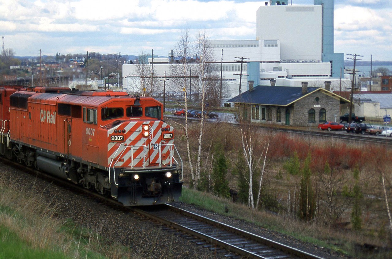 CP's Expressway heads westbound behind SD40-2F 9007, having crossed the long bridge over the Ganaraska River in Port Hope. VIA's (ex-CN) Port Hope Station is below along the parallel CN Kingston Sub, and the Cameco Nuclear Plant is in the background.