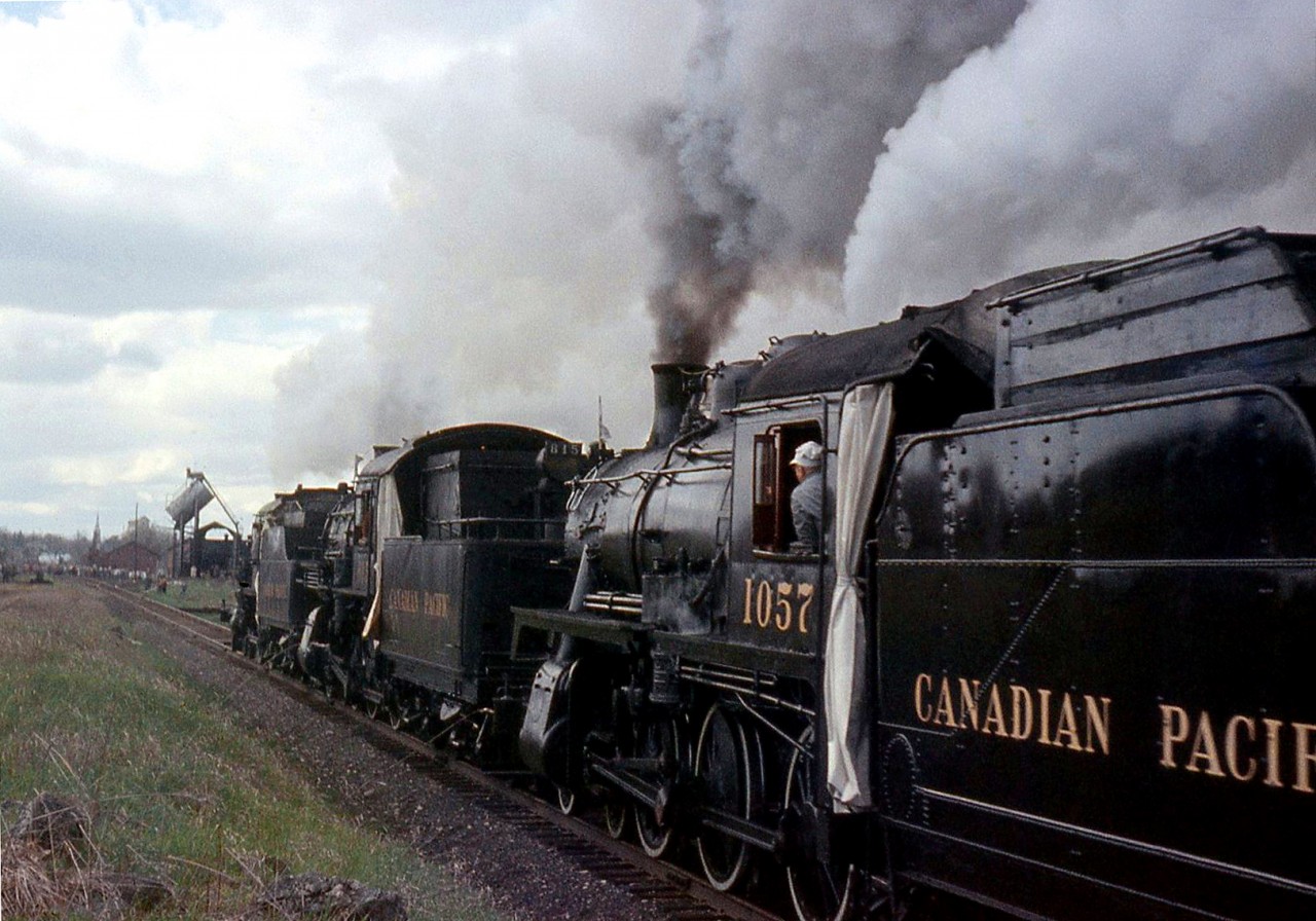 The famous CPR triple header steam excursion is shown approaching Orangeville yard on its trip north, with the roundhouse, coaling tower and other railway facilities visible in the distance. The special train operated from Toronto to Orangeville and back on May 1st 1960, powered by ancient 4-4-0 136, and 4-6-0 D10's 815 and 1057. Two of the engines that day (136 and 1057) went on to become steam excursion stars in the following decades, and survive today on the South Simcoe Railway.