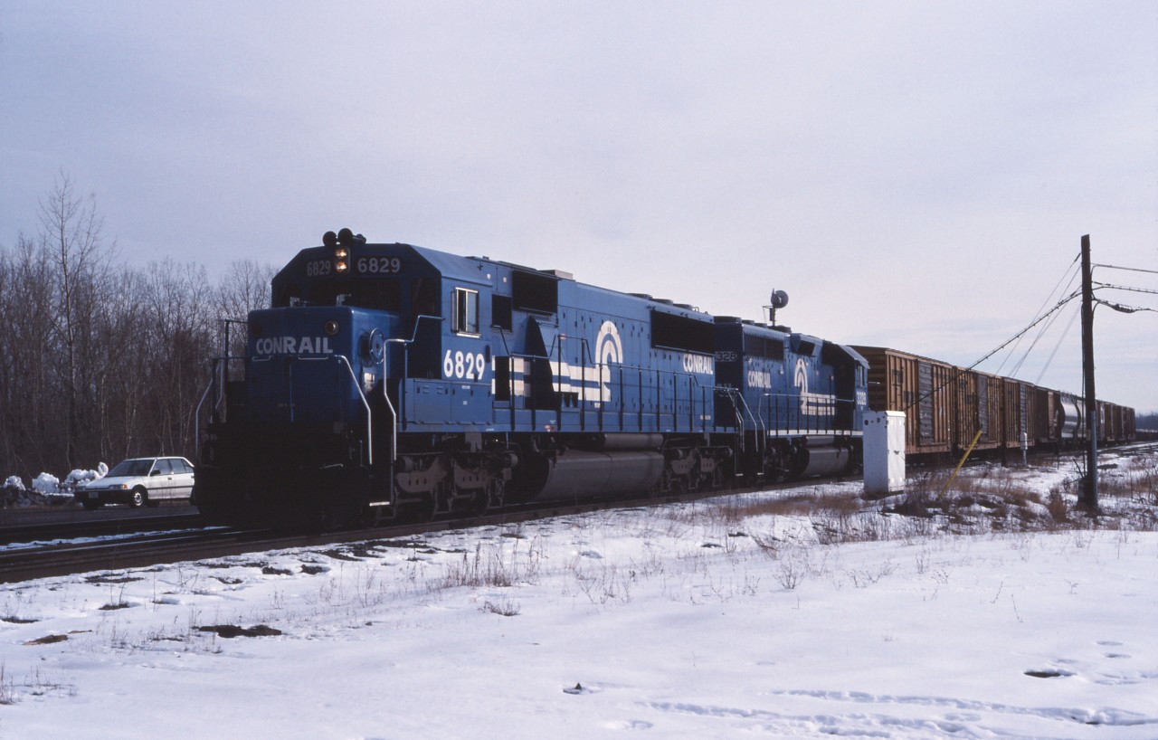 Back onto its normal routing, Conrail's Selkirk Yard to Montreal (CP St-Luc) train approaches the St. Lawrence Seaway crossing and the bridge onto the island of Montreal. The train is now led by big six-axle units such as SD50 6829, unlike the smaller power used in prior years.

Today, the 6829 has been retired by Norfolk Southern and the former Conrail line through Adirondack Jct and Chateauguay is quiet with CSX traffic operating through Valleyfield.