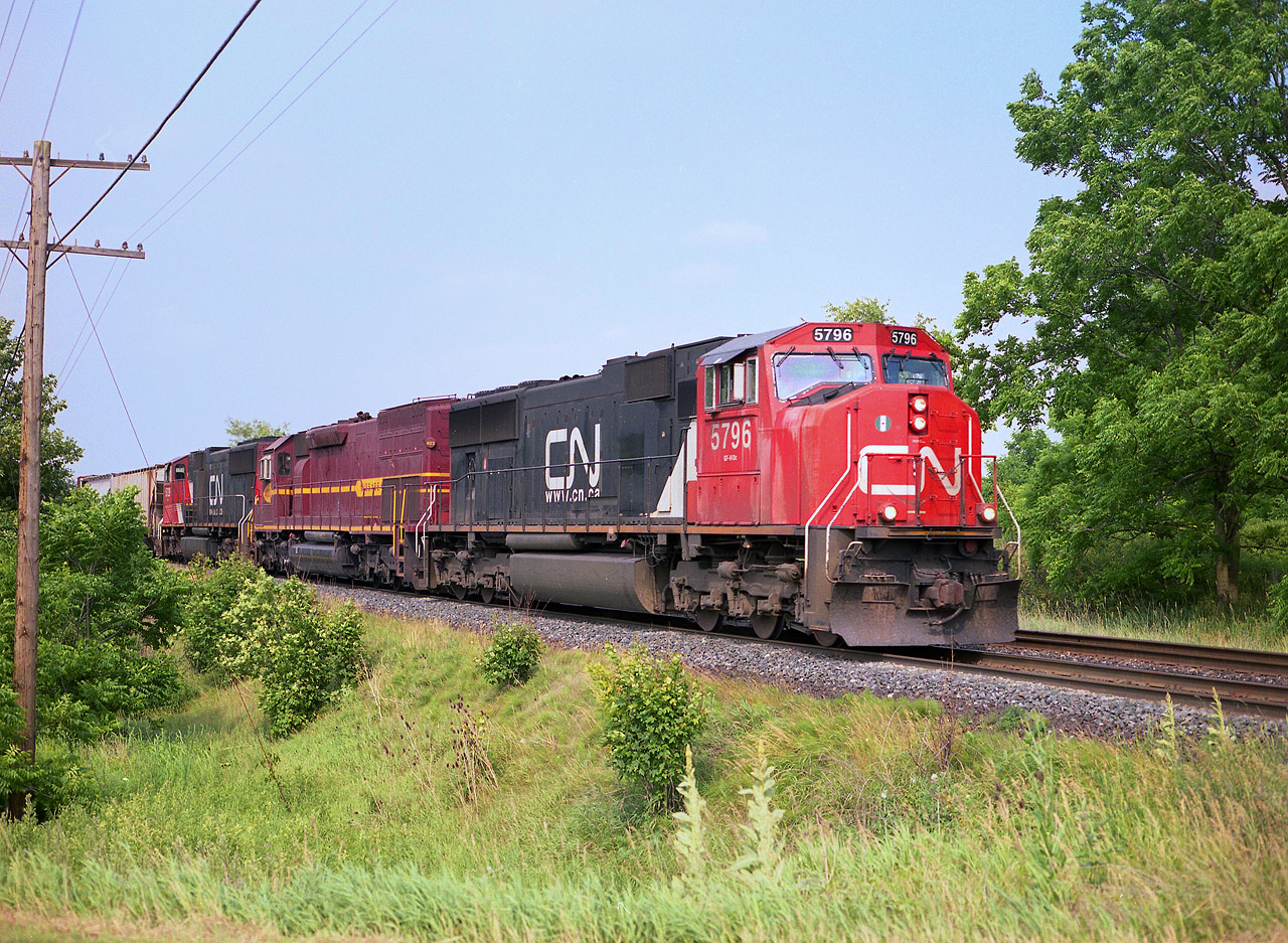 Sandwiched between these CN SD75s is  Duluth, Missabe & Iron Range (DMIR)#403, now a SD40-3; a rare treat in Southern Ontario. I saw this unit go by when in Dundas, and gave chase just because I may not see one along this line again. And I never did, other than units done over in CN. I would imagine they are all now sporting their CN jackets, and according to CTG there are but 9 left of the original 20 in this series. The DMIR was acquired by CN two years before this photo was taken. Power is CN 5796, DMIR 403 and CN 5729.