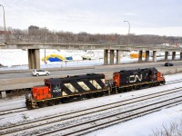 A pair of GP9's (CN 4102 & CN 7054) are running around their train near Turcot West in Montreal.
