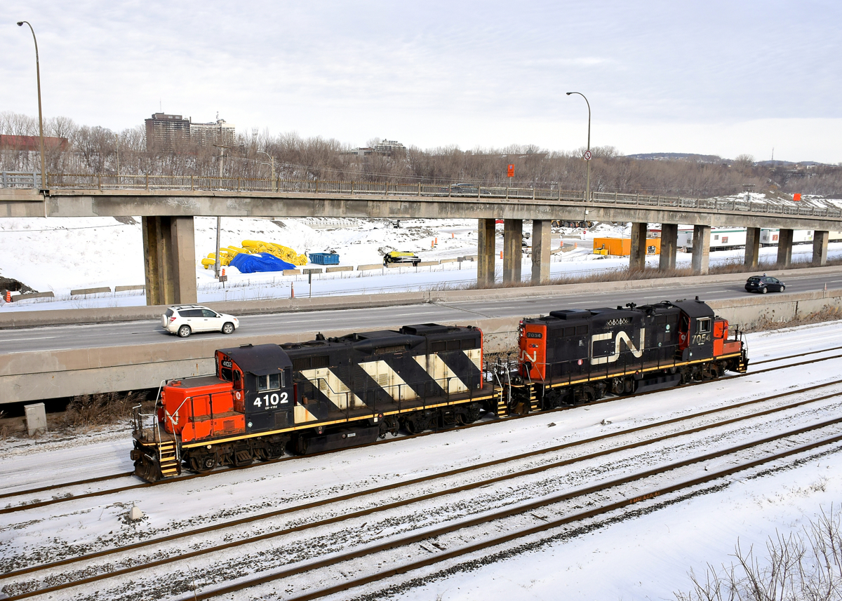 A pair of GP9's (CN 4102 & CN 7054) are running around their train near Turcot West in Montreal.