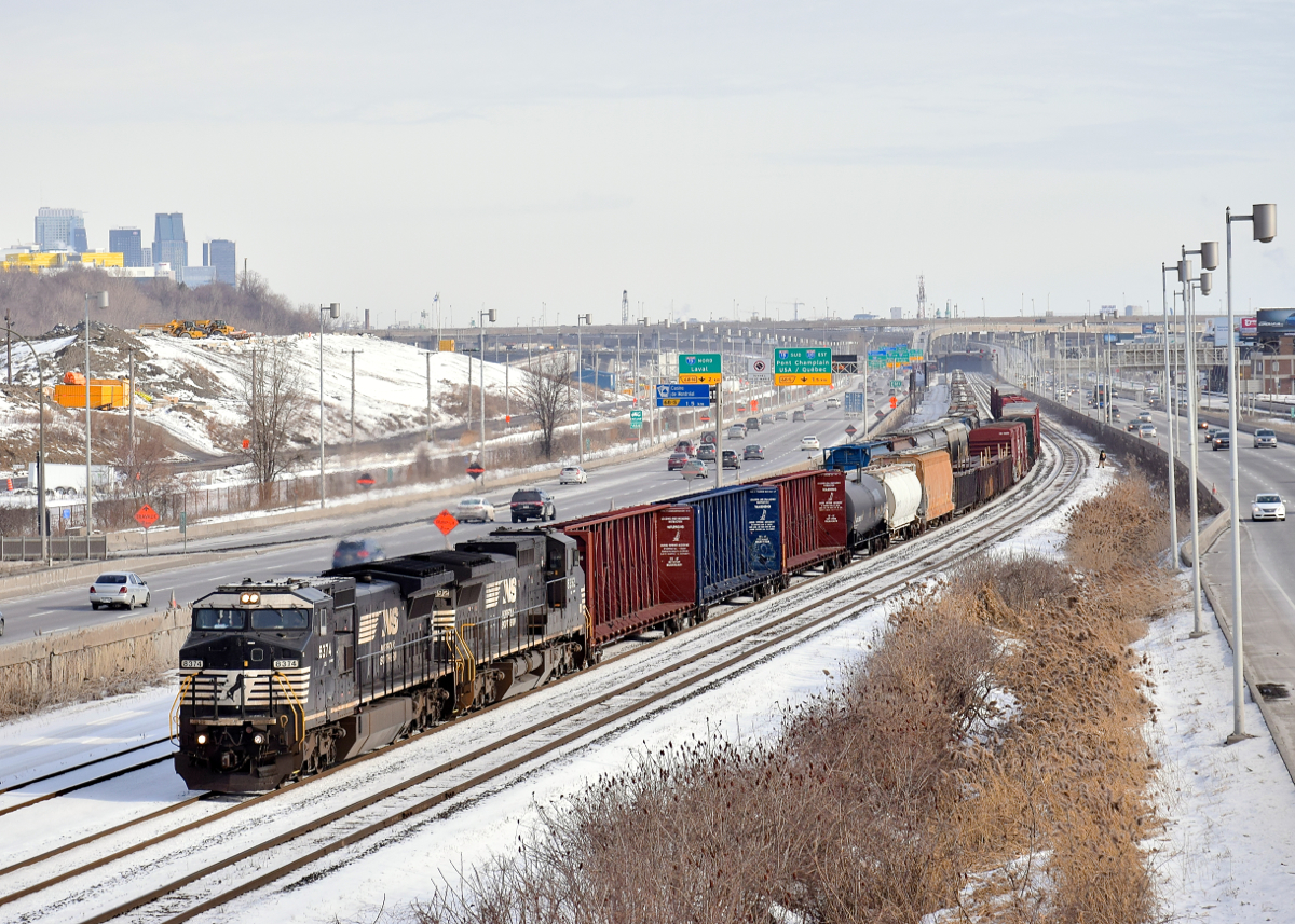 A pair of ex-Conrail Dash8's (NS 8374 & NS 8392) lead a customarily short CN 529 towards nearby Taschereau Yard. At left in the background is part of the skyline of downtown Montreal.
