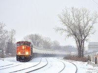 CN 585 with two strings of TankTrain loads (34 cars total) for Maitland, Ontario is westbound through Dorval on a snowy morning. Leading is GP40-2L(W) CN 9531 leading, with SD40-3 GTW 5951 trailing out of sight as the train rounds an s-curve. Barely visible in the distance is the tail end of CP 112.