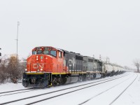 CN 585 with two strings of TankTrain loads (34 cars total) for Maitland, Ontario is westbound through Dorval on a snowy morning. Leading is GP40-2L(W) CN 9531, with SD40-3 GTW 5951 trailing.