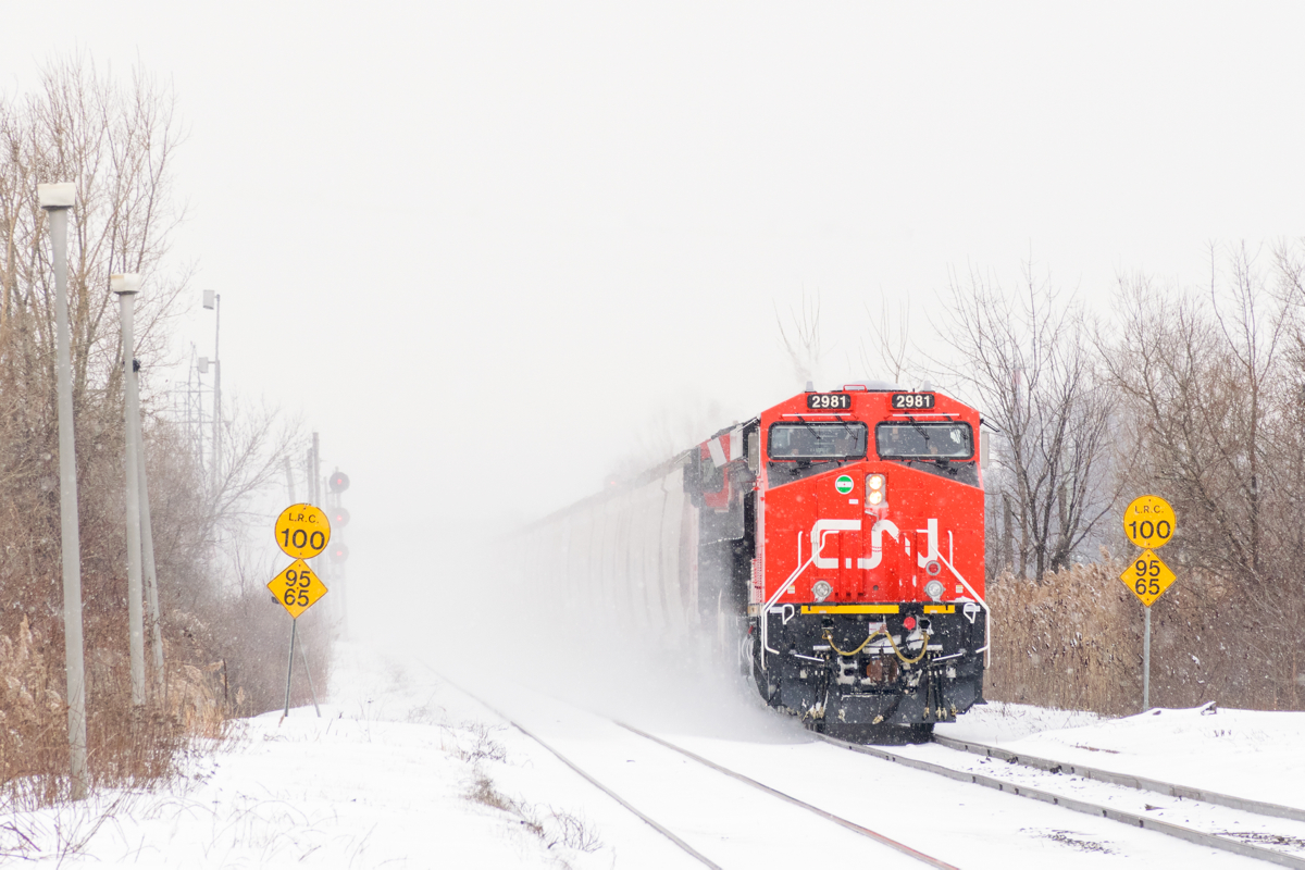 Loaded potash train CN B730 is crossing from the south track to the north track at Dorval on a snowy day, though with the train kicking up so much snow you can't really tell. Brand new ES44AC CN 2981 and ET44AC CN 3057 are up front and ES44AC CN 2806 & ET44AC CN 3068 are mid-train DPU's on this 205-car long train.