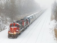 <b>I could hear it coming a mile away.</b> With heavy snow falling in Montreal this afternoon, visibility was not great. I saw a train lined westbound on the freight track of CN's Montreal Sub and I heard it well before I saw it, with two GP9's (CN 7054  & CN 4102) giving it all they've got to bring 75 cars into nearby Taschereau Yard.