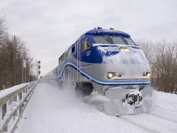 After a heavy snowstorm, snow covered AMT 80 arrives at Lasalle Station with F59PHI AMT 1327 leading.