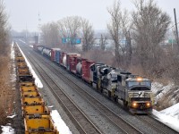 An ex-Conrail SD60I leads a pair of ES44AC's on CN 529 as it approaches Taschereau Yard. At left are stored well cars.