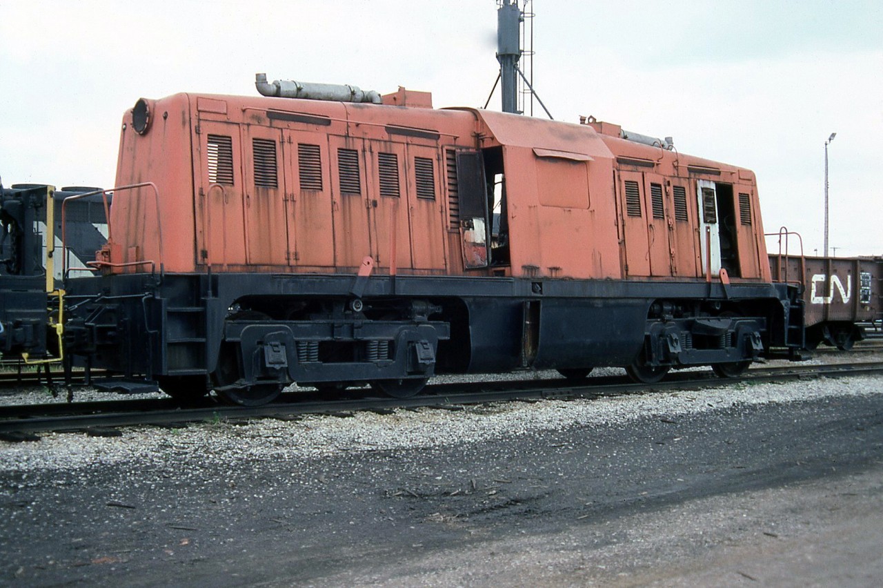 The former Dofasco 6, a 65-ton Whitcomb centre-cab switcher, is seen stored at CN's Fort Erie yard on April 30th 1987.

According to Ray Kennedy's Old Time Trains  page, this unit was one of six ex-US Army Whitcomb 65-ton switchers acquired after World War Two for switching Dofasco's internal trackage at their Hamilton plant. The last operable unit, it suffered an engine failure and was stored out of service in 1969. It was eventually moved to CN's Fort Erie yards where it was stored for many years earmarked for preservation, but ultimately destroyed by arson.