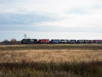 Oh boy. What do you do when you see a consist like this? And it is coming straight out of the morning sun! I remember what I did. I panicked!! :o) I don't recall exactly how this opportunity came about, but it was most likely set in motion by a phone call from my buddy Pete Hoople in Welland; who often checked out the yard down his way and of course hearing NS leader on the scanner would certainly start the 'motor running'. I knew in advance it was a 'lot of power'. But not like this! There was absolutely no angle as the sun was right down the tracks, so I had to find a broadside. This train was at speed. Maybe 45 MPH. Whatever it was, it left little room for error so I guessed as to just how wide the scene needed to be to capture the maximum of units. This was not bad, all things considered. On the head end are NS 8941, CP 5749, CEFX 3166, GMTX 9046, CEFX 3164, ICE 6444, 6449 and SOO 6044. I doubt a variety pack like this will never be duplicated along this line.