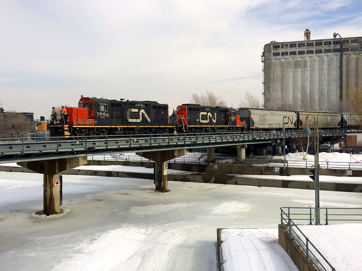 GP9's CN 7054 & CN 7015 are advancing over the Lachine Canal with a cut of grain cars before backing up towards Bickerdike pier.