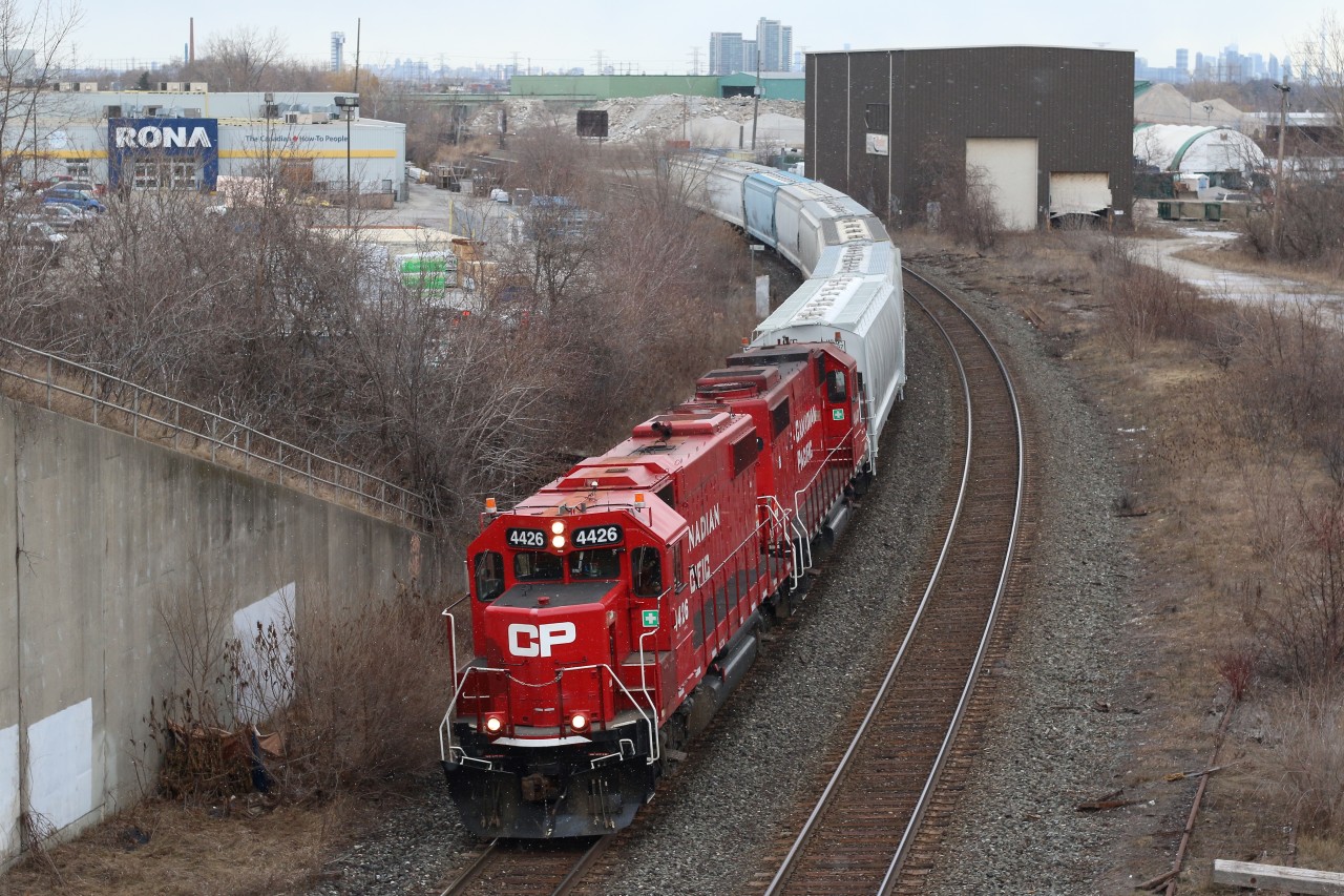 The grey weather has brought in snow flurries as Streetsville bound local T14 with a pair of former SOO Line GP38s passes the sad remains of the one time busy steel coil transfer facility in Cooksville. The early 2000s would find a new larger transfer facility built in Hamilton, making this one, once operated by Ryder redundant.