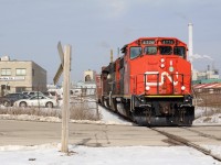 Very little remains of the former H&NW original right of way through Milton. In 1960 it was completely rebuilt and for the most part relocated and elevated. The town line spur is just a small section of that old alignment. Here local 551 lifts one centre beam car from the busy Taiga forest products facility along the old spur. They will spot a few loads before heading north to Mansewood to run around there train and head back to Aldershot. 