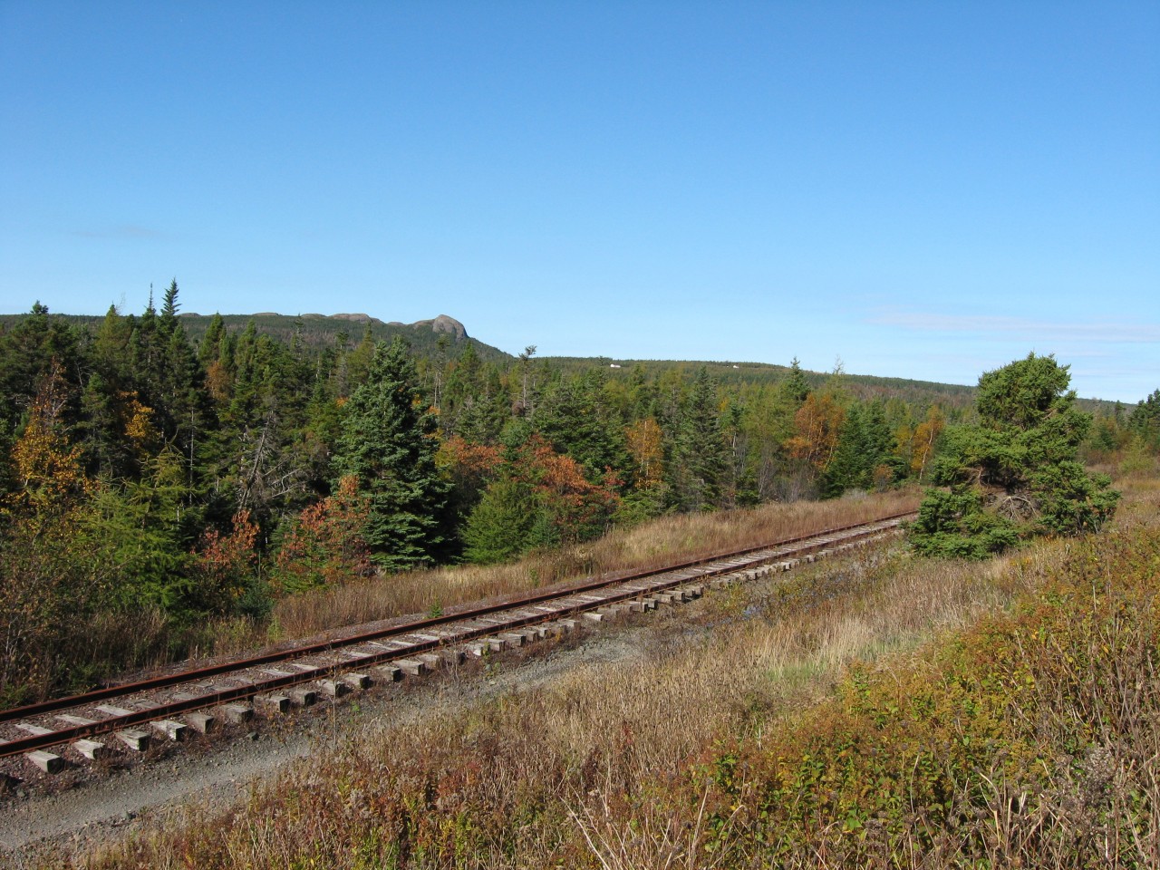 ALL THAT REMAINS. Just west of Avondale, lies the longest remaining stretch of the former Newfoundland Railway mainline. For 1.8 miles, this section of track survived the dismantling program thanks to the hard work of the Avondale Heritage Society who also managed to preserve the Provinces' oldest wooden station in that community. With the backdrop of the Blue Hills, the last official scheduled train to run past this area was Terra Transport Extra 944 East heading to St. John's with five NF210's, two gondolas of scrap metal and a caboose on a rainy September 29, 1988. A testament to the track crews is evident in the remarkable condition of the line a quarter of a century later, considering that no maintenance has been since that time.