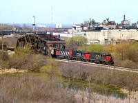 A favourite shooting place that was, in my own mind, underutilized. Just didn't have the time, and it wasn't long after discovering this spot that it became overgrown and off limits. It is now fenced off private property of Walker Industries (Quarries) But I did get a couple of nice shots here....a spot initially located as I was trying to find a scene for the start up of AMTK thru Niagara that would not be duplicated by other photographers. And succeeded. In this shot, CN 5513, 5500 and 9499 are Niagara-bound thru 'CN Iron Bridge'. The sprawling Glendale Av GM plant dominates the background. Two GP38-2 and a GP 40. I loved that plain black with white noodle scheme for some odd reason.