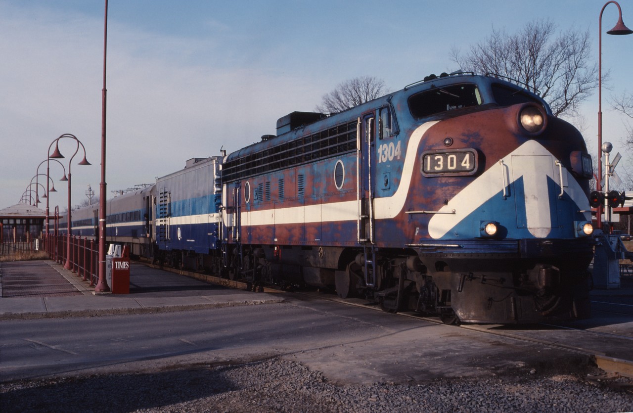 When this shot was taken in 1990, AMT 1304 had already been in service for 28 years. Built for Canadian Pacific in 1952, it carried road numbers 4074 and 1430 before retirement in 1982. It was subsequently sold to the Montreal Urban Community Transit Commission when they took over CP’s “Lakeshore” commuter service in 1982, rebuilt, and served another 20 years (retired in 2002). Saturday-only train 50 was photographed at the Beaurepaire commuter stop in Beaconsfield on a snowless winter day.