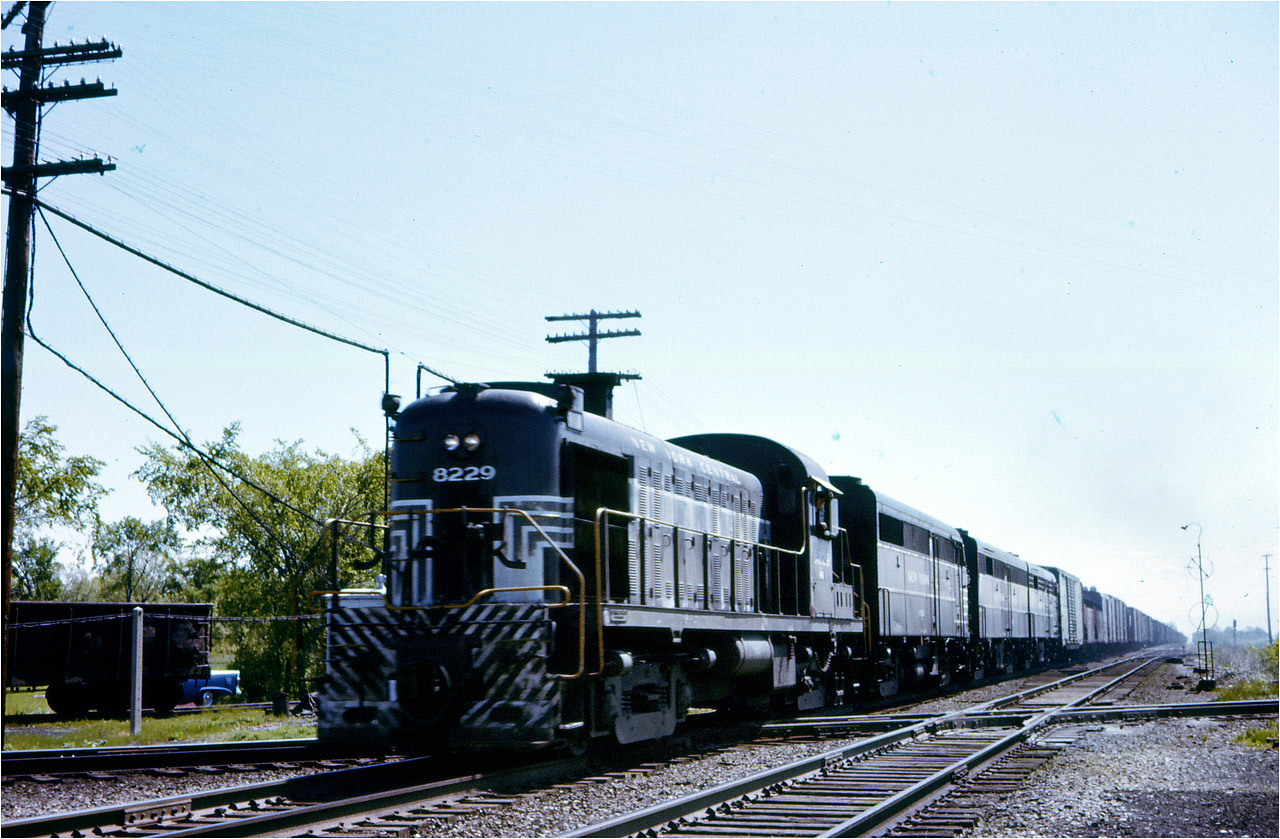 An Alco RS3 - a rare leader even in 1961-  is in charge of an eclectic mix of motive power on this long westbound freight at Canfield.