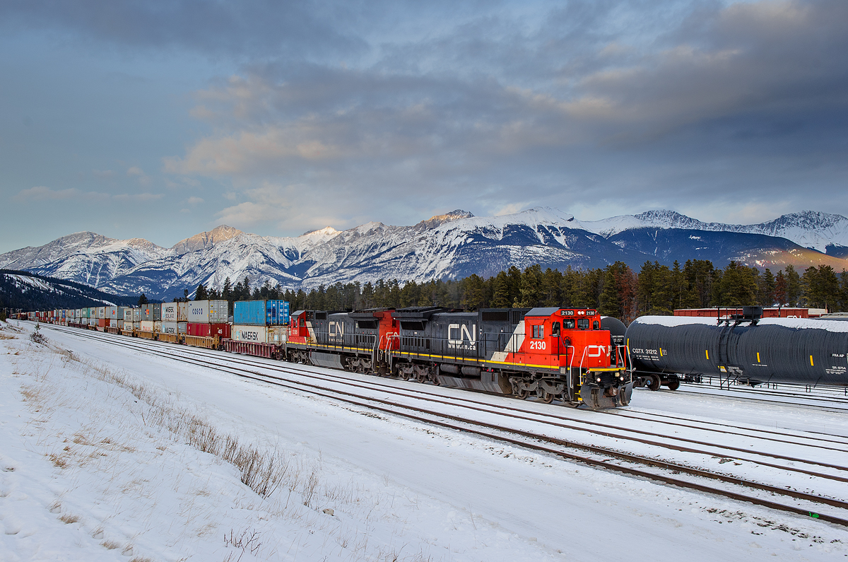 The sun had set behind Whistler's Mountain in Jasper, AB for the day, however, with a cool sky hanging over the Colin Range and a cool set of power bringing in the once a week Memphis-Prince Rupert train Q197, I decided to snap a shot. CN must have faith in these old girls, as C40-8s 2130 and 2105 were put to task to lead this 12258' monster across the country.
