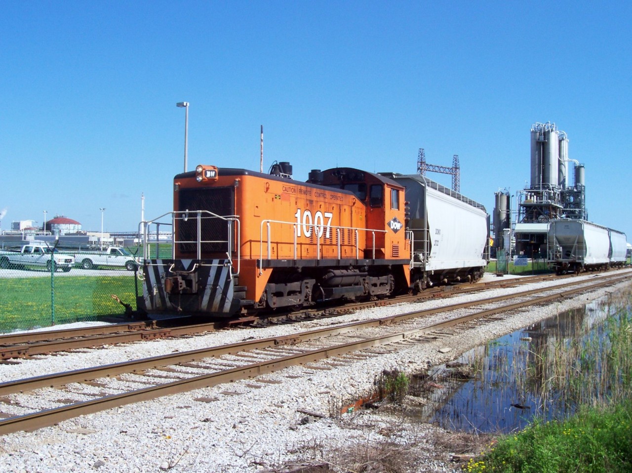 Here we have the DOW 1007 switching cars into the large DOW Canada facility at Sarnia, Ontario. Located just south of the main CSX yard cars were switched in and out of the plant by the 1007 and left on the "old C&O main" as seen in the photo. 

Sadly this is all gone now with the DOW facility closing, the tracks were removed and most of the plant was demolished. Thankfully the switcher was sold to VIP Rail in Sarnia and lives on.